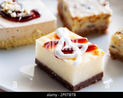 White plate full of different pastries. Tasty desserts with topping, nuts and cream in shape of treble clef. Stock Photo
