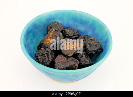 Cut dried figs in blue bowl close-up. Stock Photo