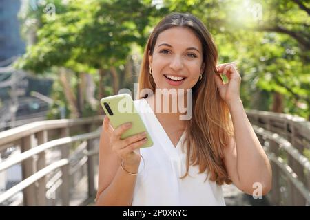 Close-up of beautiful business woman holding smartphone looking at camera Stock Photo
