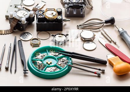 spare-parts, tools and used watches on wooden table in watchmaker workshop Stock Photo