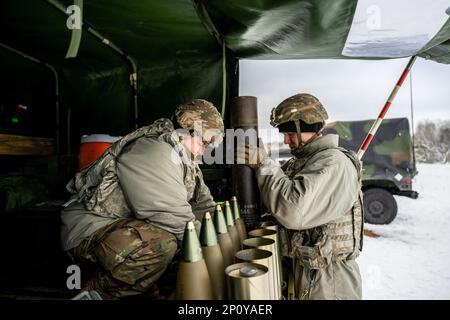 Army Cpl. Brady Kielpikowski and Pfc. Dominic Tilton, 1-120th Field Artillery Regiment, assemble a 105mm High Explosive shell to be used with the M119 howitzer during Northern Strike 23-1, Jan. 23, 2023, at Camp Grayling, Mich. Units that participate in Northern Strike’s winter iteration build readiness by conducting joint, cold-weather training designed to meet objectives of the Department of Defense’s Arctic Strategy. Stock Photo