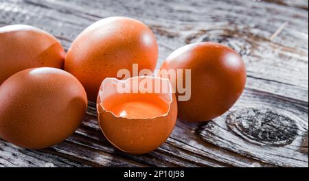 Composition with five chicken eggs on a wooden table. Stock Photo