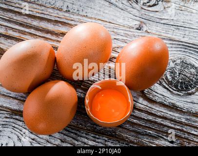 Composition with five chicken eggs on a wooden table. Stock Photo