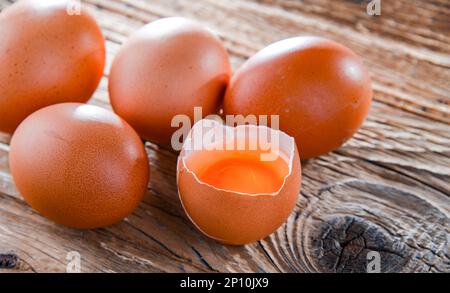 Composition with five chicken eggs on a wooden table. Stock Photo