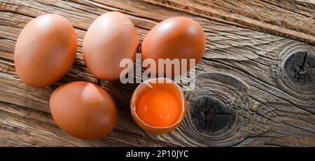 Composition with five chicken eggs on a wooden table. Stock Photo