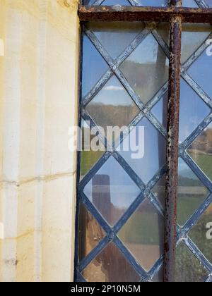 Detail of a decorative lattice window with rusty iron bars. Stock Photo