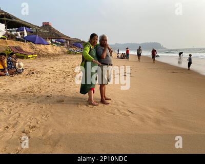 Candolim, Goa, India - January 2023: An elderly Indian man and woman standing on a beach and having a conversation. Stock Photo