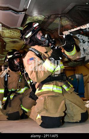 (Left to right) Senior Airman Dustin Fahlbusch, fire protection journeyman, and Duncan Hutchinson, firefighter, both with 775th Civil Engineering Squadron Fire Department, practice emergency engine shutdown on a salvaged aircraft Jan. 25, 2023, at Hill Air Force Base, Utah. This was one of several scenarios practiced during an emergency responder working group exercise attended by first responders from across the Air Force to explore emergency engine shutdown and aircrew extraction best practices specific to F-35 aircraft. Stock Photo