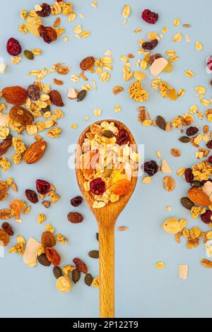 Wooden spoon with muesli on blue background Stock Photo