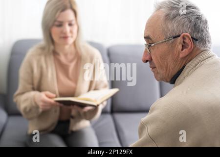 Close up anxious serious old man listening to female doctor at meeting in hospital, therapist physician consulting mature patient about disease Stock Photo