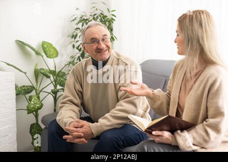Close up anxious serious old man listening to female doctor at meeting in hospital, therapist physician consulting mature patient about disease Stock Photo