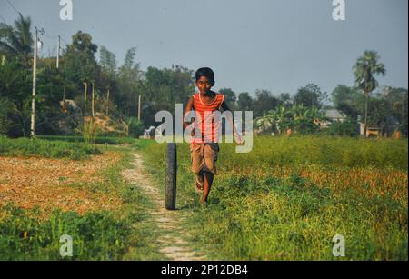 Some children playing traditional games in an open fiend in a village in Bangladesh. Stock Photo