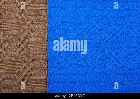 Knitted blue and brown background. Large knitted fabric with a pattern. Close-up of a knitted blanket. Stock Photo