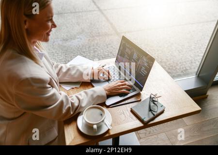 Woman freelance programer working on laptop while sitting in cafe. Data done right Stock Photo