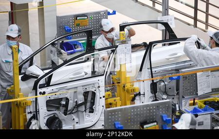 (230303) -- GUANGZHOU, March 3, 2023 (Xinhua) -- Staff members install door sealing strips at the assembly line of GAC Aion, an NEV subsidiary of Guangzhou Automobile Group Co., Ltd. (GAC Group), in Guangzhou, south China's Guangdong Province, Feb. 24, 2023. Guangzhou, one of China's major car manufacturing bases, has been striving to attract investment in NEV industry in recent years. (Xinhua/Deng Hua) Stock Photo