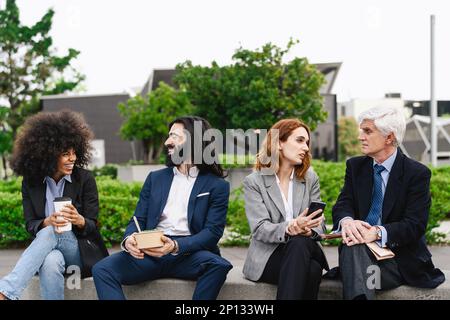 Multiracial business people with different ages having a lunch break outside office Stock Photo