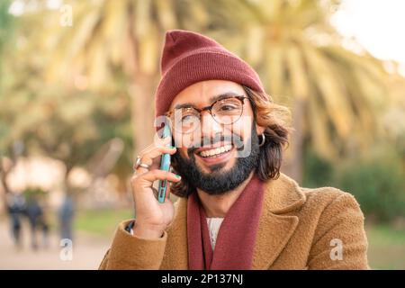 Attractive young caucasian man with glasses and beard taking a selfie outdoors in the park. Stock Photo