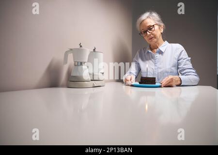 Sad woman celebrates her birthday alone at home Stock Photo