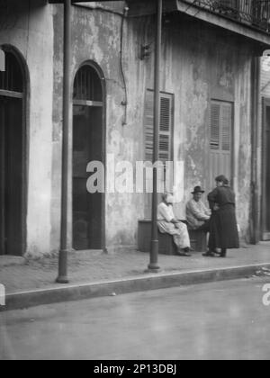 View from across street of people talking, New Orleans, between 1920 and 1926. Stock Photo