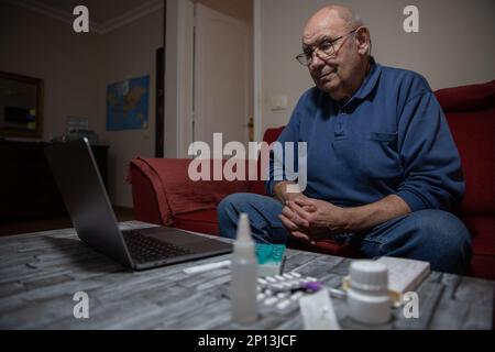 An elderly man makes a video call with his general practitioner, telehealth concept Stock Photo