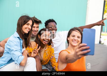 Multiracial group of friends making a selfie with phone in the university - friendship, happiness and joyful concept Stock Photo
