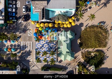 An aerial view of a Fort Lauderdale beach cool off area with gazebos, colorful umbrellas, shaded areas and palm trees on a sunny day Stock Photo