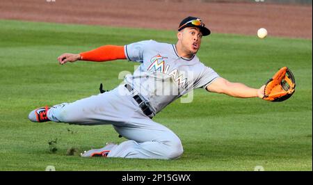 St. Louis Cardinals Aledmys Diaz retrieves a Jose Fernandez shirt that hung  in the dugout for their game against the Cincinnati Reds at Busch Stadium  in St. Louis on September 27, 2016.