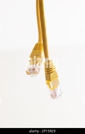 Yellow Ethernet cable connectors close up shot isolated on white macro. Stock Photo