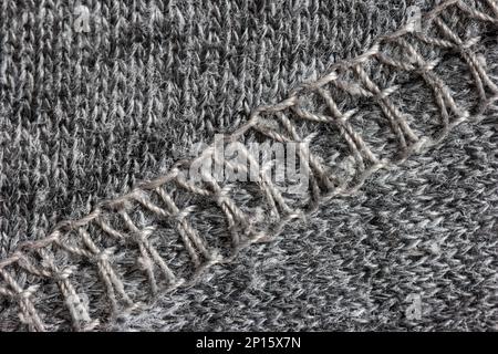 Grey cloth fabric background texture with diagonal stitched seam macro top view. Stock Photo