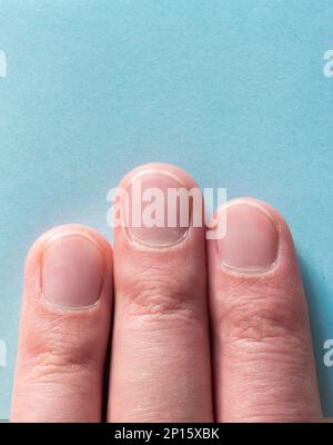 Three male fingers on blue background top view macro shot . Stock Photo
