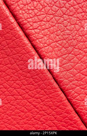 Red leather pattern scales texture macro close up shot front view diagonal stitched seam. Stock Photo