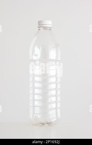 Clear empty plastic bottle with red lid isolated on white vertical shot. Stock Photo