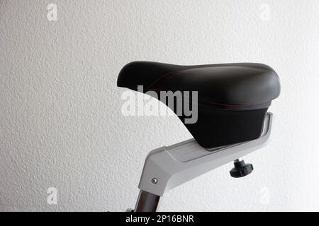 Indoor exercise bike saddle close up shot isolated on white. Stock Photo