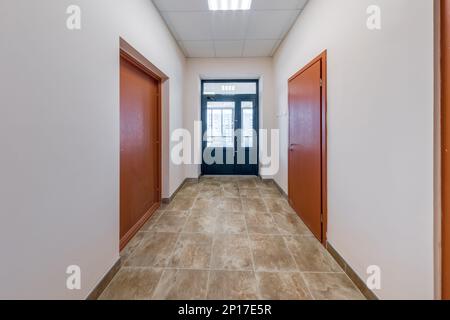 white empty long corridor with red brick walls in interior of modern apartments, office or clinic. Stock Photo