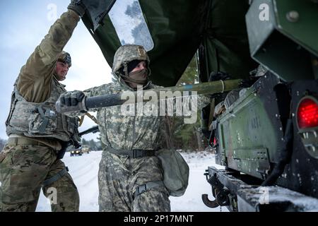 Army Sgt. Meranda Leisgana gets help from Pfc. Cameron Patzner, both from 1-120th Field Artillery Regiment, as she pulls out a crossbar for the M119 howitzer during Northern Strike 23-1, Jan. 25, 2023, at Camp Grayling, Mich. Units that participate in Northern Strike’s winter iteration build readiness by conducting joint, cold-weather training designed to meet objectives of the Department of Defense’s Arctic Strategy. Stock Photo