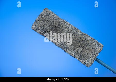 Dirty and used cleaning mop and towel isolated on blue background studio shot. Stock Photo