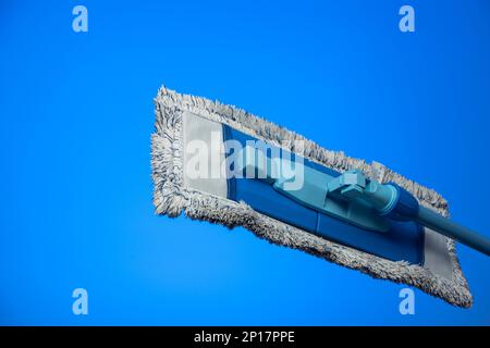 Dirty and used cleaning mop and towel isolated on blue background studio shot. Stock Photo