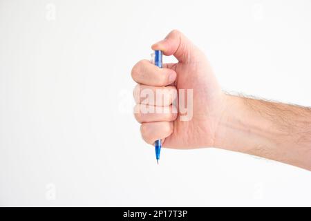 Blue plastic ball pen held in hand by Caucasian male hand making gesture studio shot isolated on white. Stock Photo