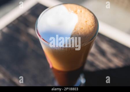 Cup of greek ice cold coffee on a table, frappe, glass of freddo, fredo capuchino served in street cafe taverna, Corfu island, Kerkyra, Greece, greek Stock Photo