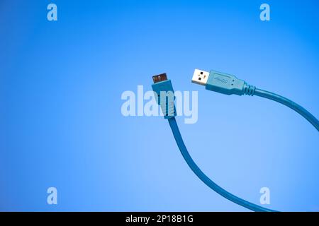 Blue folded HDMI cable studio shot isolated on blue background. Stock Photo