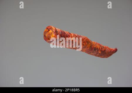 Home made Hungarian style smoked spicy sausage close up studio shot isolated on gray background. Stock Photo