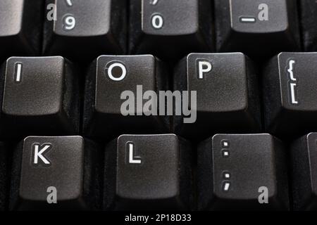 Black plastic standard English computer keyboard close up macro shot top side view. Stock Photo