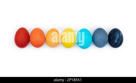 Easter multi-colored eggs laid out in a row isolated on a white background. Happy easter eggs painted rainbow colors close up photo with copy space. G Stock Photo