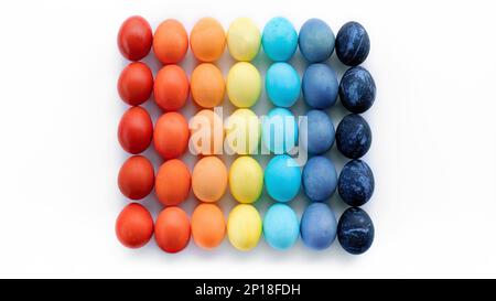 Modern easter concept. Colored eggs laid out in a square by color on a white background with copy space. Contemporary art easter banner in techno styl Stock Photo