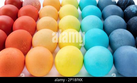 Happy Easter bright backgrounds. with copy space.  Easter eggs pattern for banners. Rainbow colored chiken eggs are laid out in a gradient on a white Stock Photo