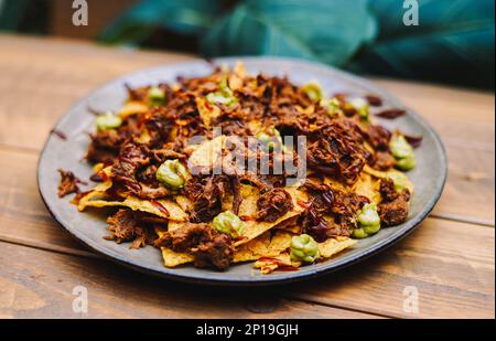 Mexican nachos with beef and chilli on wooden table Stock Photo