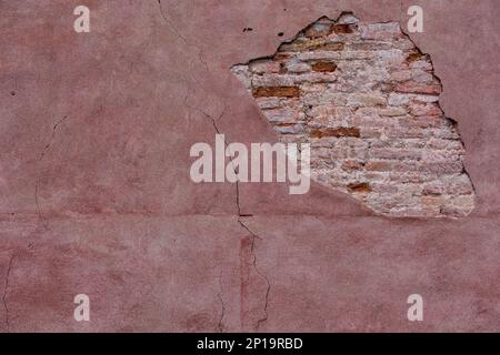 Opening on a wall of a house in Venice. You can see the bricks and the details of the wall. Pink and highly detailed texture. Stock Photo