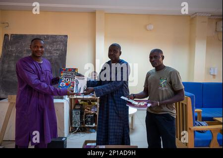 A staff member (left) of the American Cultural Center, Agadez, Niger, and members of the Niger Armed Forces (FAN), Affair Civil Militaire (ACM), pose for a photo with books the FAN ACM donated to the center’s library Jan. 14, 2023. The 443 Civil Affairs Battalion, from AB 201, facilitated the meeting and then attended an English discussion group afterwards. Stock Photo