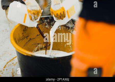 epoxy flooring applicator performs painting works with polyurethane epoxy mortar Stock Photo