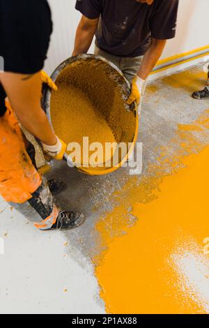 epoxy flooring applicator performs painting works with polyurethane epoxy mortar Stock Photo